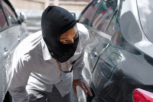 Masked thief in black balaclava trying to break into car © tuaindeed