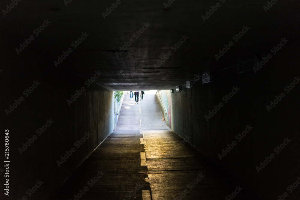 underpass in urban city with light at the end