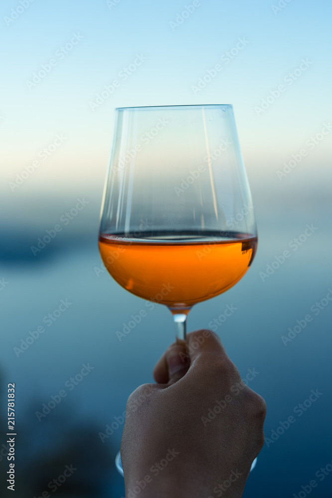 wine glass with drink in front of blue lake iconic background