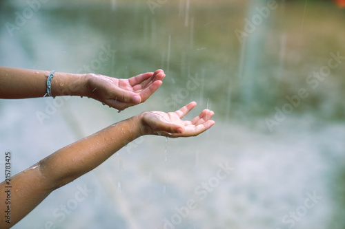 children putting hands in the rain catching drops of rain © Natsicha