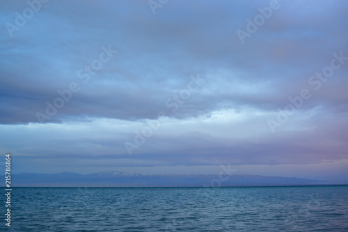 Scenic view of lake with grey mountains on horizon  