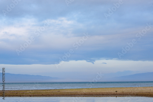 Scenic view of lake with grey mountains on horizon © photollurg