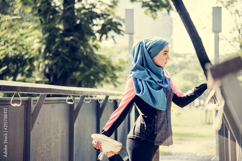 Islamic woman stretching after workout at the park