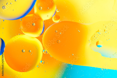 Beautiful color abstract background from mixied water and oil. Pastel colored abstraction. Yellow and blue background from water bubbles.