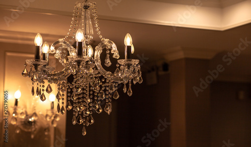 Chrystal chandelier lamp on the ceiling in Dining room Adjusting the image in a Luxury tone .Decorative elegant vintage and Contemporary interior Concept. photo
