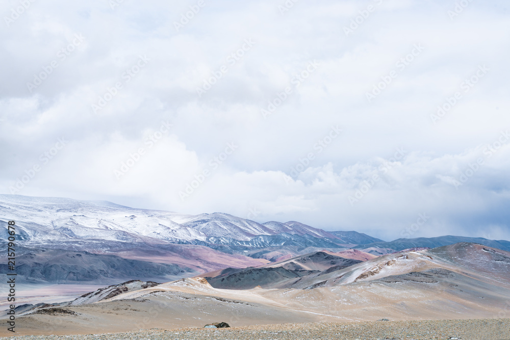 Panoramic view of snowy mountains under cloudy sky
