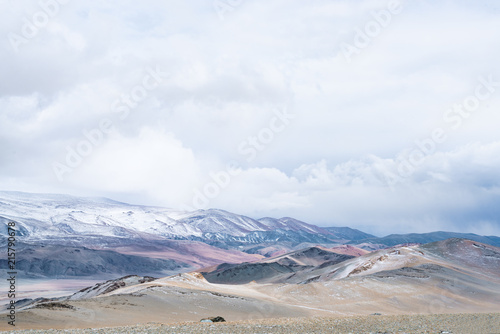 Panoramic view of snowy mountains under cloudy sky 