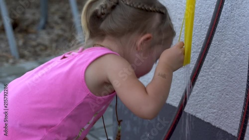 4K footage of cute little girl drinking from a water hose