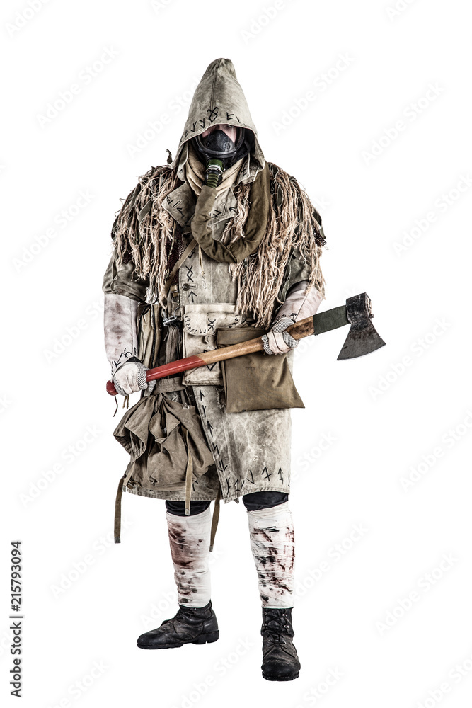 Obraz premium Post apocalypse world survivor, bandit or marauder in gas mask, ghillie cape, ragged clothes with runes, showing beckoning sign while standing with carpenters axe in hand, isolated on white shoot