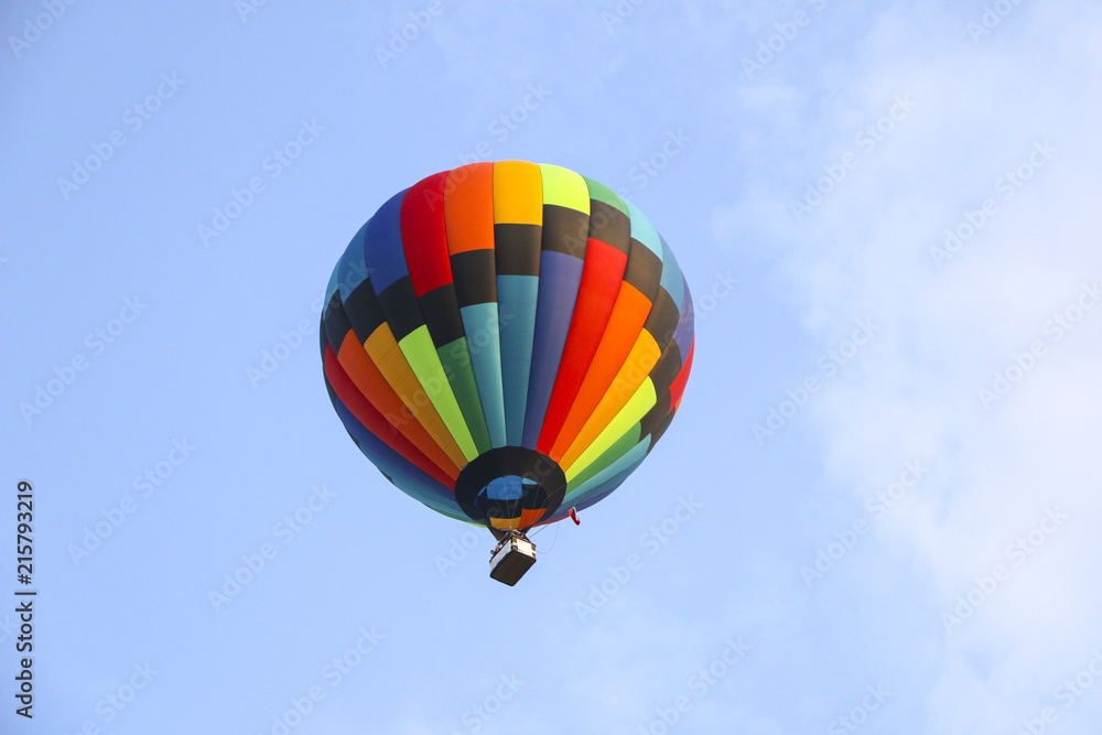 colorful hot air balloon against blue sky. hot air balloon is flying in white clouds. beautiful flying on hot air balloon colorful hot air balloon against blue sky. hot air balloon is flying in white clouds. beautiful flying on hot air balloon
