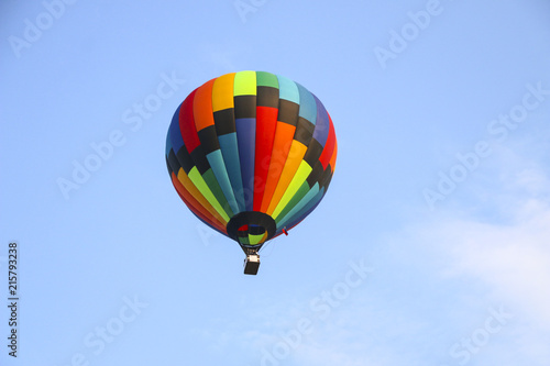 colorful hot air balloon against blue sky. hot air balloon is flying in white clouds. beautiful flying on hot air balloon
