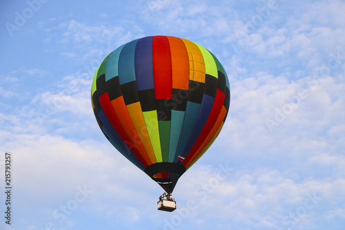 colorful hot air balloon against blue sky. hot air balloon is flying in white clouds. beautiful flying on hot air balloon © Оксана Скиданова