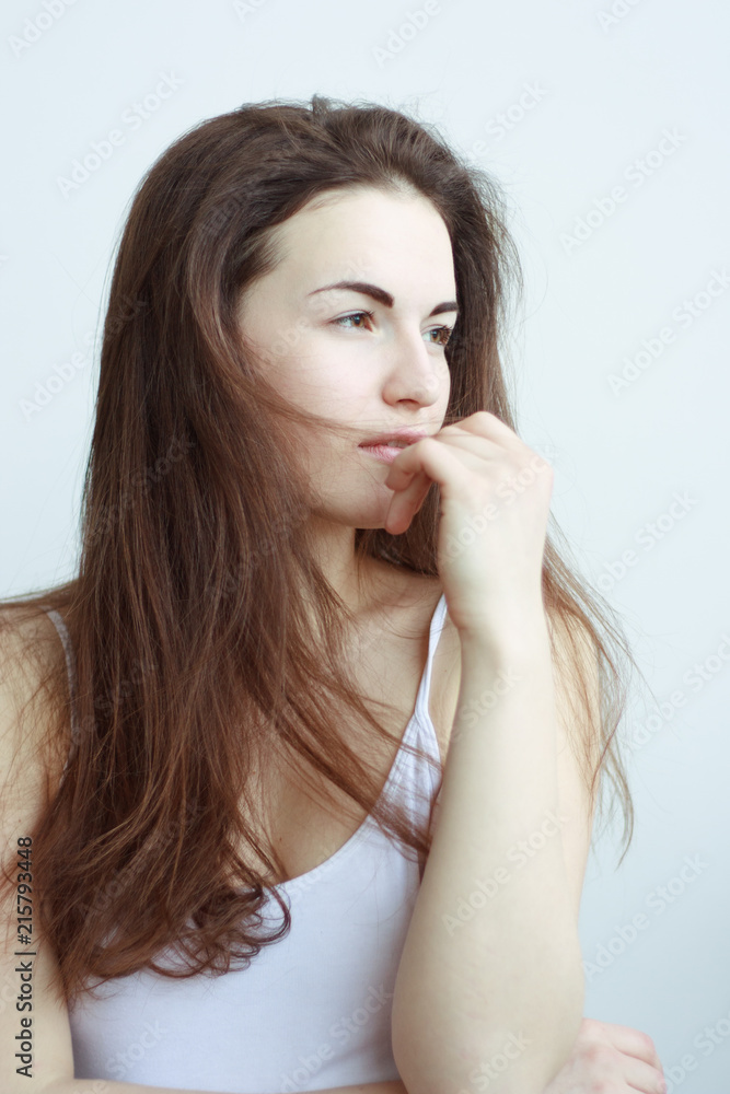 Close-up portrait of pensive woman with long hair looking up in light Close-up portrait of pensive woman with long hair looking up in light