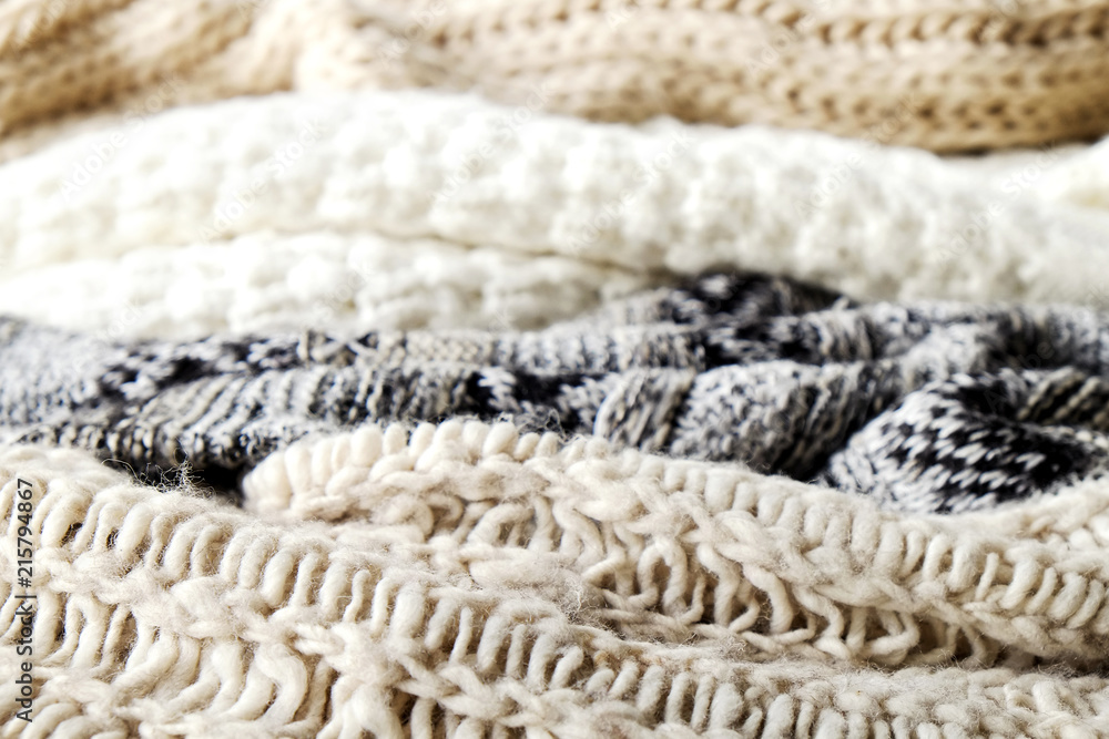 Bunch of knitted warm pastel color sweaters with different knitting patterns laid in messy pile, clearly visible texture. Stylish fall / winter season knitwear clothing. Close up, copy space for text. Bunch of knitted warm pastel color sweaters with different knitting patterns laid in messy pile, clearly visible texture. Stylish fall / winter season knitwear clothing. Close up, copy space for text.