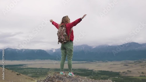 Wallpaper Mural tourist girl with a backpack is standing on the edge of the cliff and enjoying the opening view of the valley. the traveler raises his hands and upwards rejoicing at the achievement of the goal. Torontodigital.ca