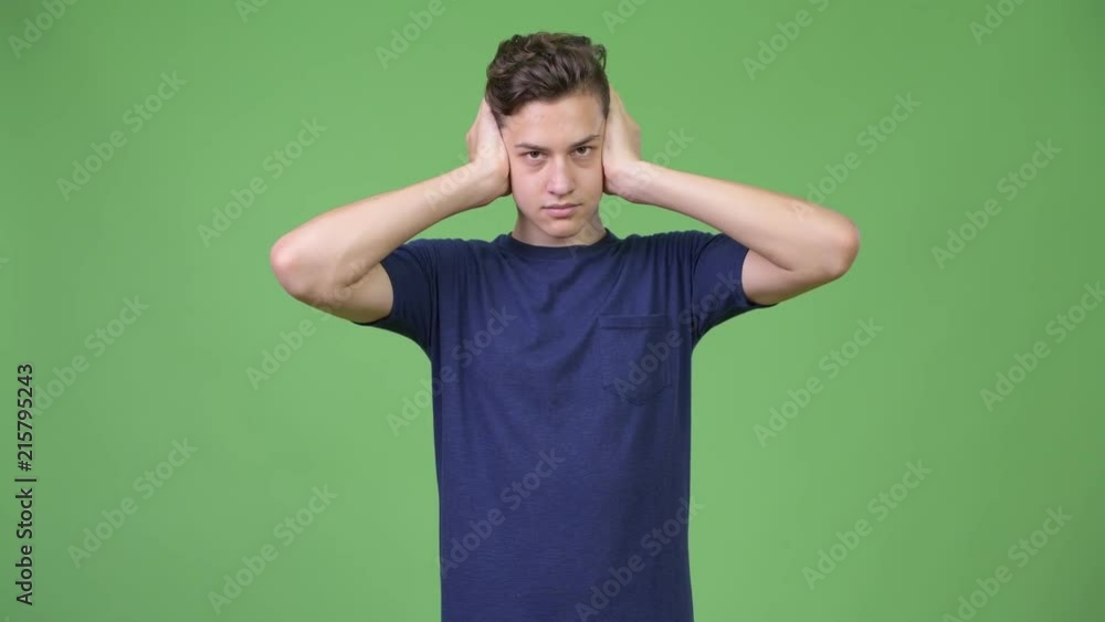 Young handsome teenage boy covering ears as three wise monkeys concept Young handsome teenage boy covering ears as three wise monkeys concept