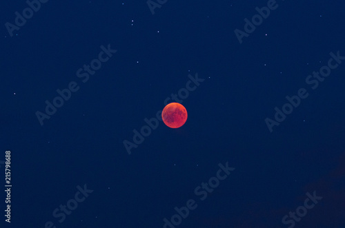 Total lunar eclipse on the evening of July, the 27th 2018 with red moon and stars ín the blue sky