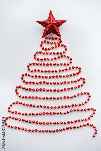 Creative idea in minimalistic style for Christmas or New Year themes. Christmas fir-tree from beads and a star on top. Festive concept