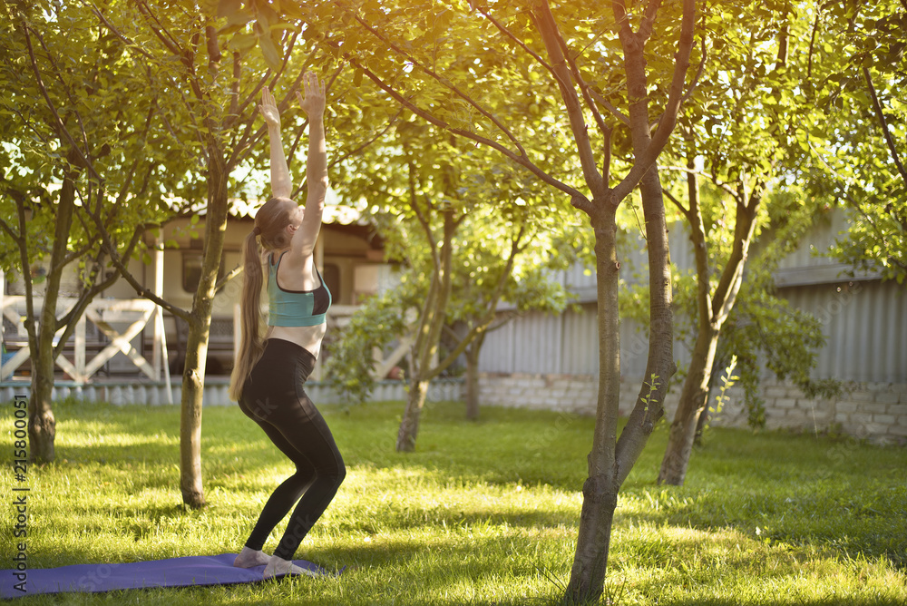 Pregnant woman in the garden practices yoga, greeting the sun. Summer morning. Pregnant woman in the garden practices yoga, greeting the sun. Summer morning.