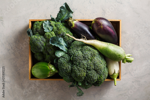 Green vegetables in a wooden box, top view.