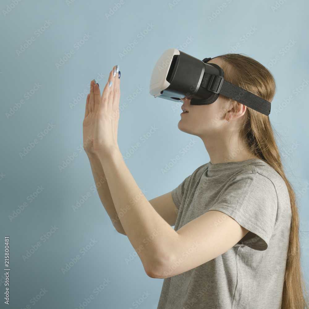 Young woman with glasses of virtual reality. Blue background Young woman with glasses of virtual reality. Blue background