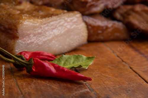 Smoked pork ribs, sliced lard, meat and red paper on wooden board photo