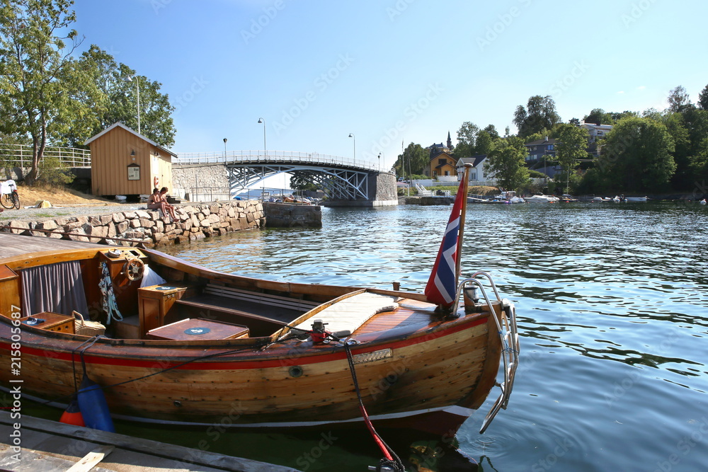 Oslo, Norway - July 22, 2018: Oslo harbor with bridge to Malmoya island in Oslofjord. Wooden boat in front of Malmoya island.