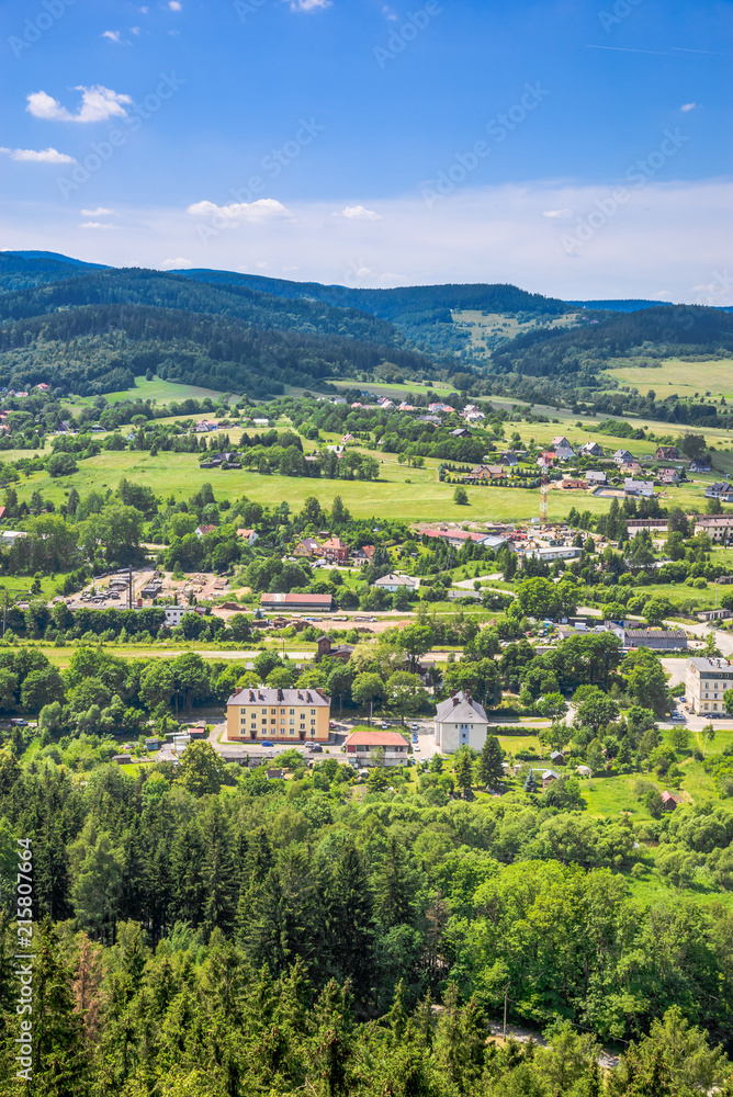 Aerial view of countryside scenery in the valley with green town and houses on foothills