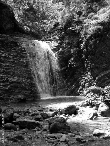 Felsen mit Wasserfall im Sommer bei Sonnenschein in der Schleifmühlklamm in den Ammergauer Alpen in Unterammergau bei Garmisch-Partenkirchen im Pfaffenwinkel in Oberbayern in klassischem Schwarzweiß photo