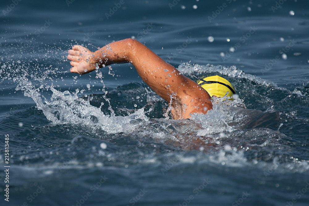 Man swimmer swimming crawl in blue sea,training for triathlon