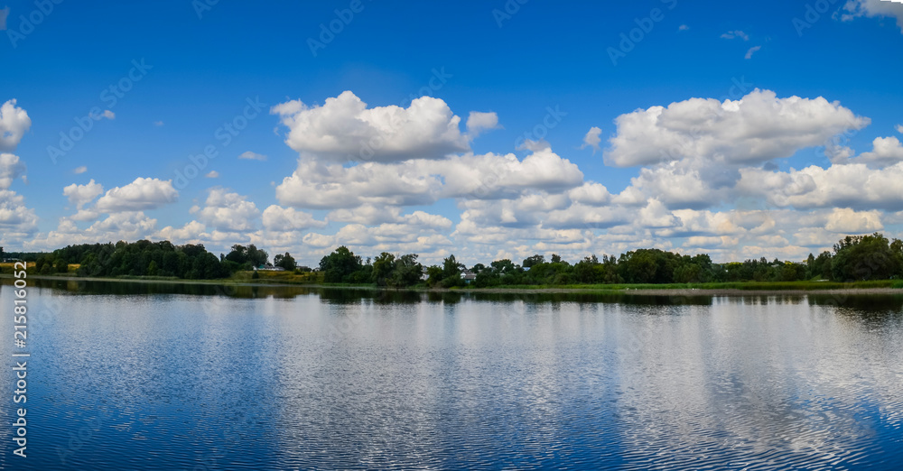Reflection of clouds in the lake. Clouds over the lake. Lake for fishing and recreation outside the city