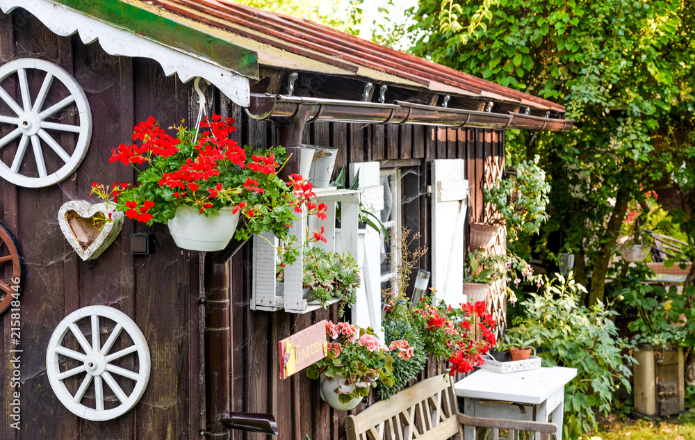 Holzhütte Gartenhütte mit Blumen im Sommer Bayern