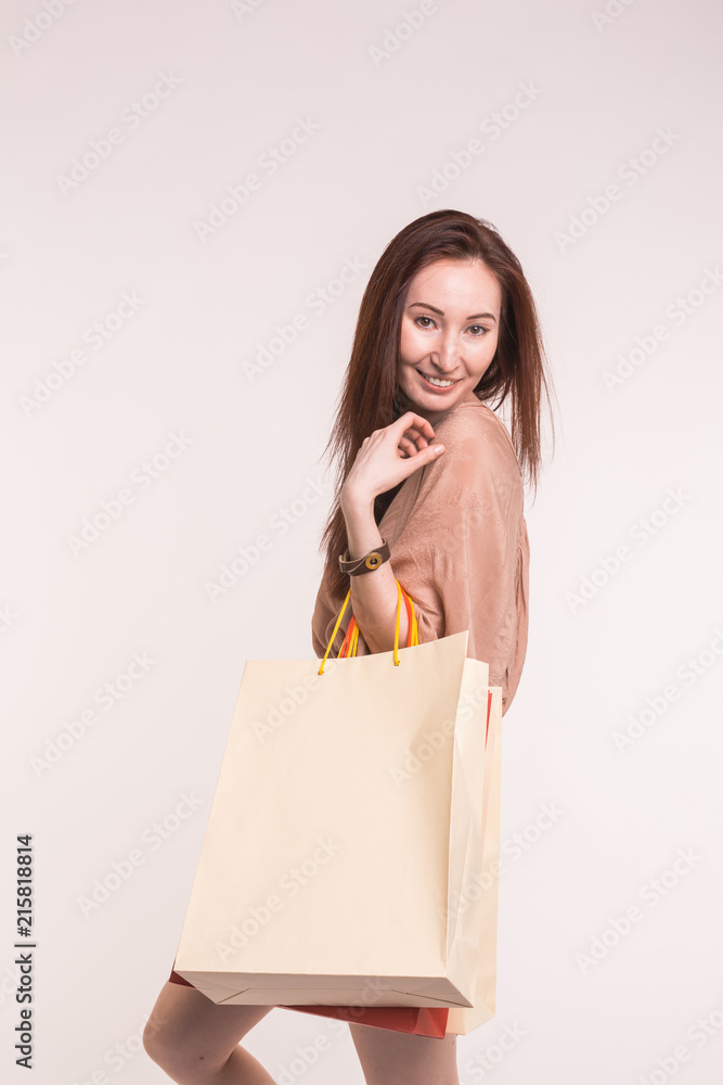 Fashion, shopping and people concept - happy brunette woman with paperbags after shopping Fashion, shopping and people concept - happy brunette woman with paperbags after shopping