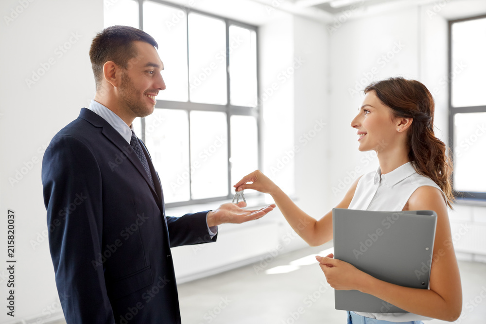 real estate business, sale and people concept - realtor giving key to customer or new office owner real estate business, sale and people concept - realtor giving key to customer or new office owner