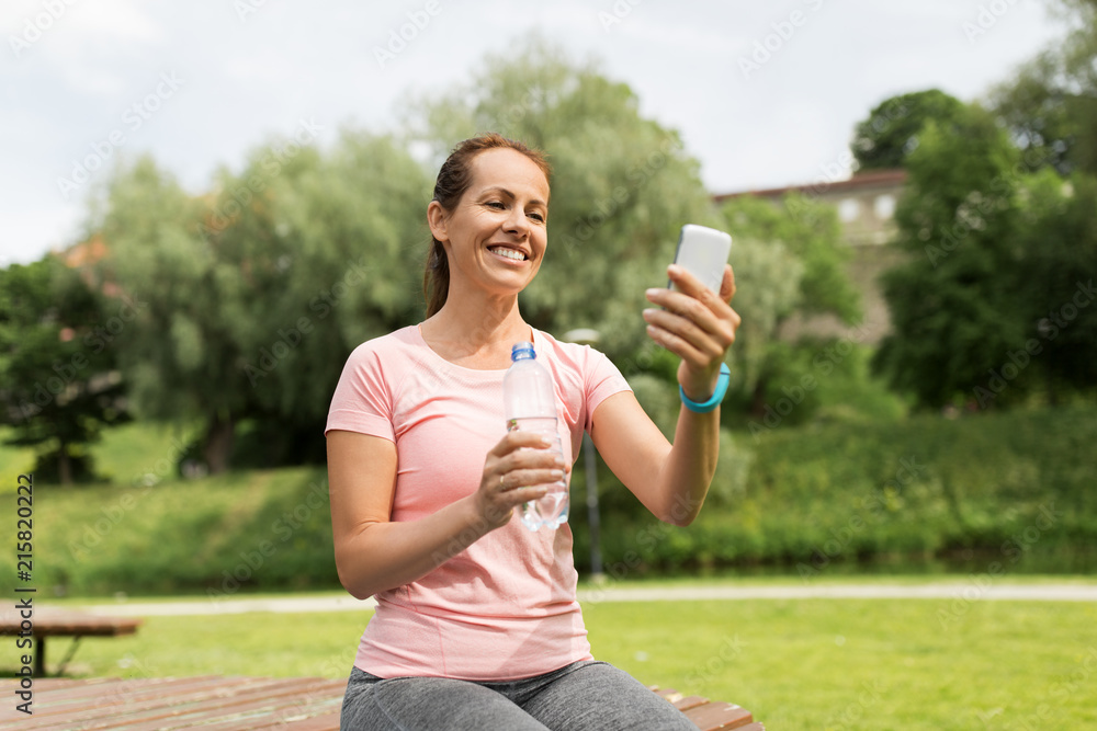 Φωτογραφία sport, technology and healthy lifestyle concept - happy woman with smartphone an