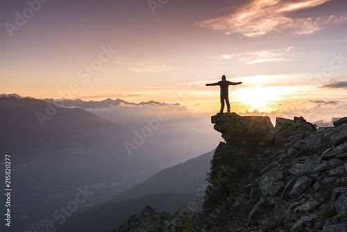 Young man standing on the Top of the mountain and enjoying total freedom during sunset in South Tyrol © rene gamper