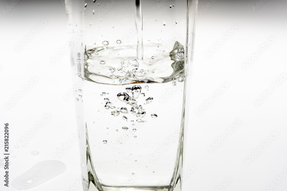Pour drinking water into the tall glass. Pour drinking water into the tall glass.