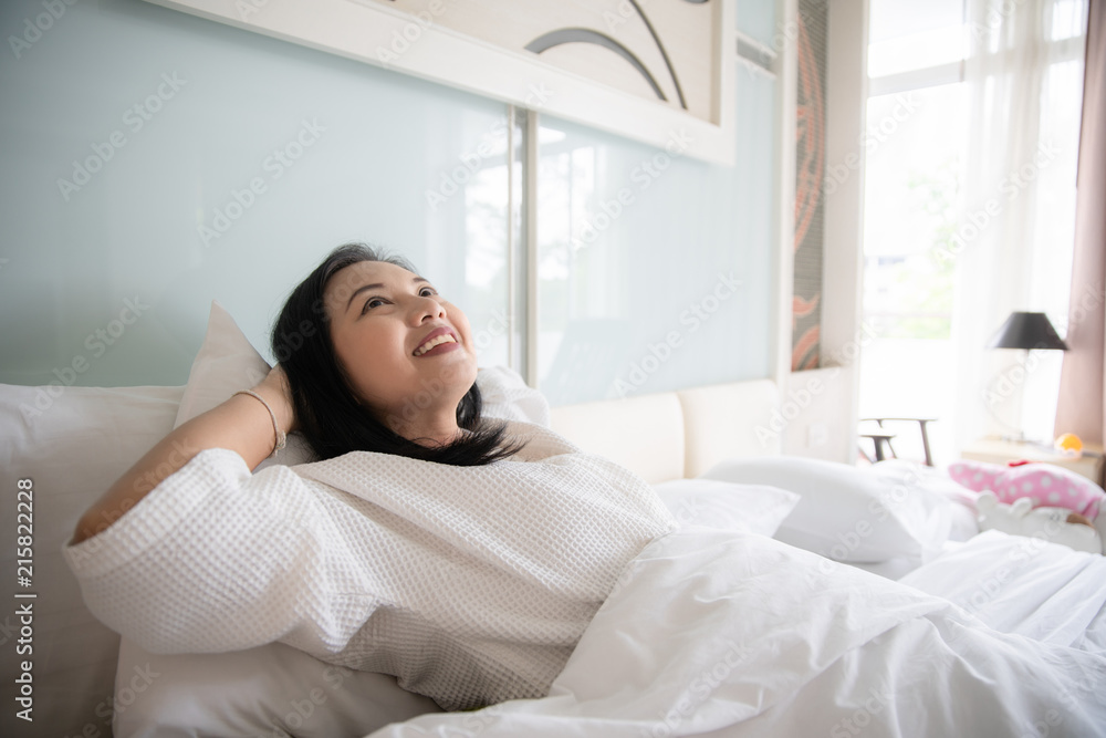 Cheerful woman wake up with fresh feeling in clean bedroom Cheerful woman wake up with fresh feeling in clean bedroom