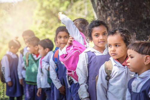 Rural Indian village school children standing outside class for morning prayer.