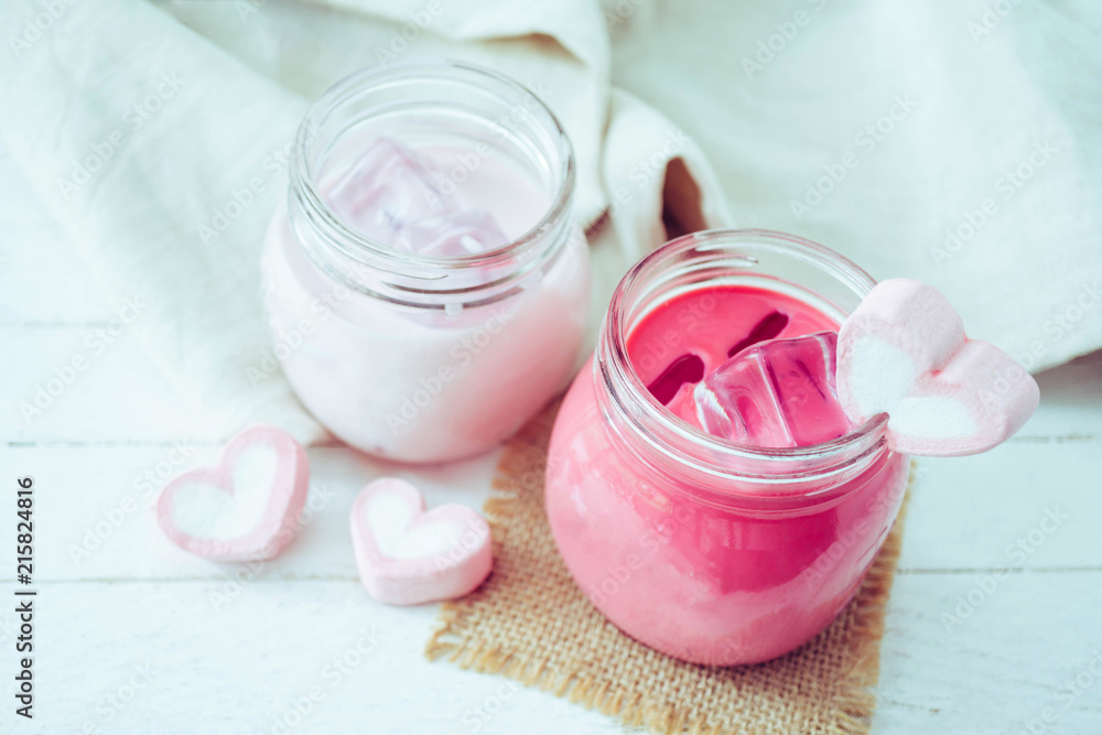 Pink milkshake with heart shape marshmallows on wood background Pink milkshake with heart shape marshmallows on wood background