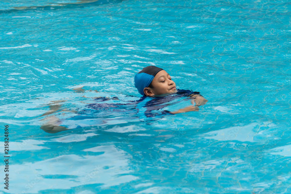 Portrait of a boy playing in public swimming pool