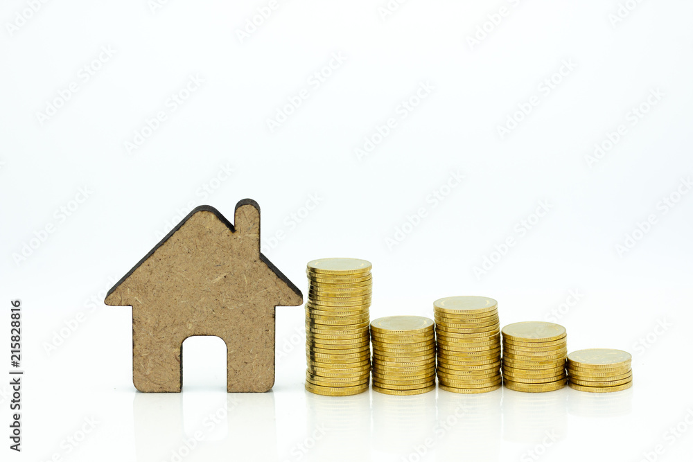 Miniature build: House resting with stack of coins. Image use mortgage and real estate investment , business concept. Miniature build: House resting with stack of coins. Image use mortgage and real estate investment , business concept.
