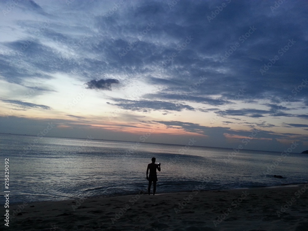Man making photo of sunset to mobile, Phuket, Thailand