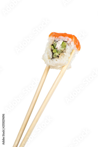 Food abstract background. Wooden sticks are holding a roll or sushi on a white background in the studio.