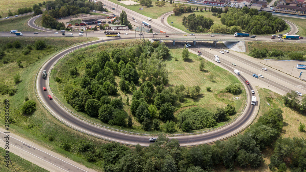 Aerial shot of a car moving on highway overpass, ringway, roundabout