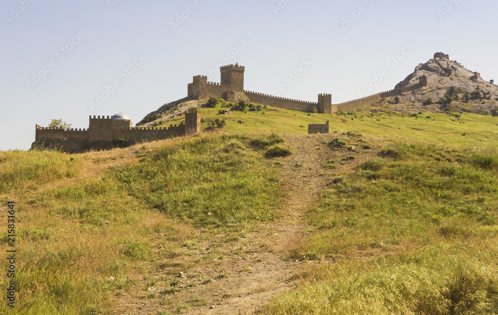 An ancient defensive fortress on a hill overgrown with green grass.Crimea.