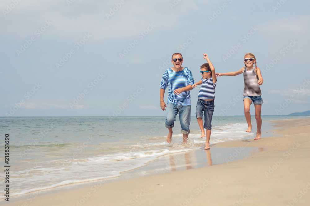 Father and children playing on the beach at the day time. Father and children playing on the beach at the day time.