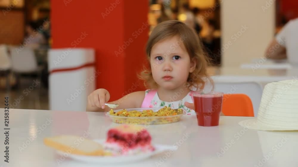 Fast food cafe. Child girl eats pilaf and drinks juice. Fast food cafe. Child girl eats pilaf and drinks juice.