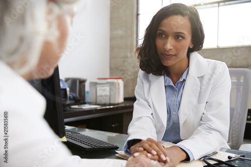 Young female doctor in consultation with senior patient photo