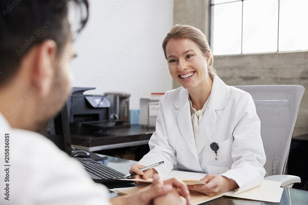Smiling female doctor in consultation with male patient Smiling female doctor in consultation with male patient